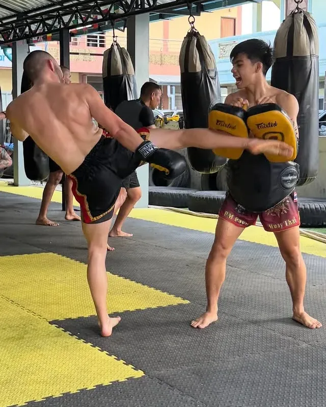 Kru Arm holding pads during training