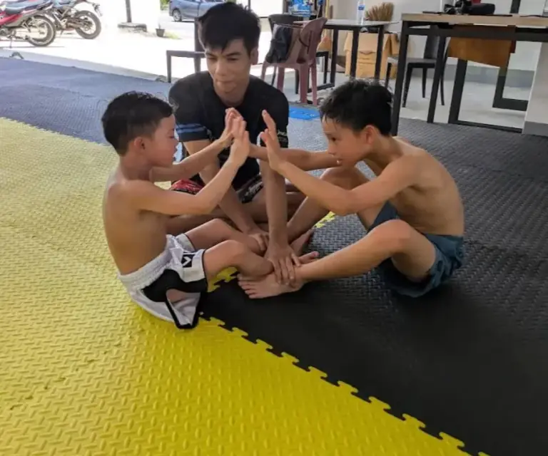 Woman doing pad work with a coach at PM PAYU Muaythai, Koh Samui
