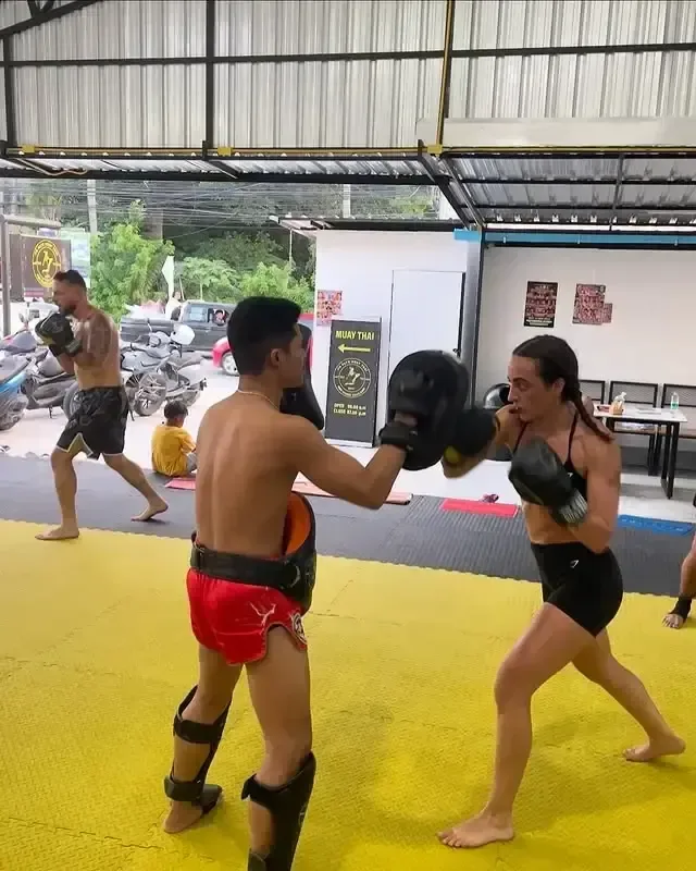 Woman doing pad work with a coach at PM PAYU Muaythai, Koh Samui